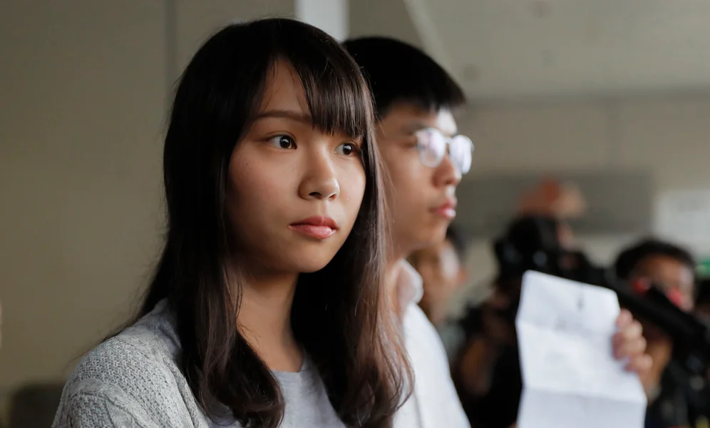 In this Friday, Aug. 30, 2019, photo, pro-democracy activists Joshua Wong, right, and Agnes Chow speak to media outside a district court in Hong Kong. Wong, Chow and activist Ivan Lam have been sentenced to jail on Wednesday, over charges related to an unauthorized anti-government protest last year at the city's police headquarters. (AP Photo/Kin Cheung)