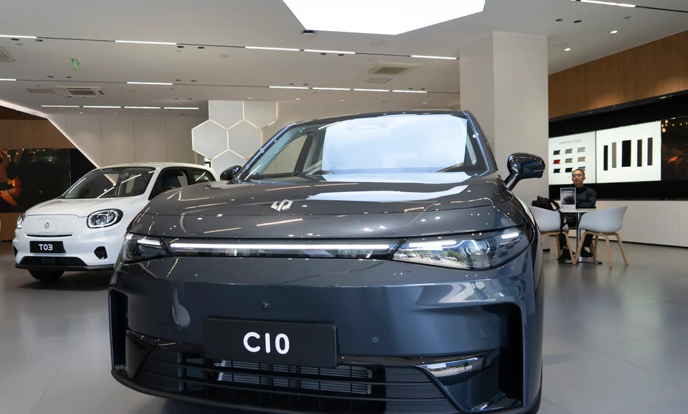 A man sits near the Leapmotor C10 model displayed at a showroom in Hangzhou in eastern China's Zhejiang province on Tuesday, May 14, 2024. European carmaker Stellantis on Tuesday said it had formed a joint venture with the Chinese electric vehicle startup Leapmotor that will begin selling EVs in nine European countries later this year. (AP Photo/Caroline Chen)
