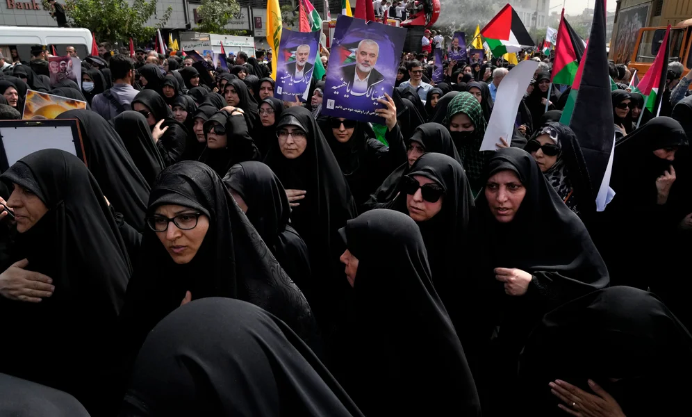 Iranians attend the funeral ceremony of Hamas leader Ismail Haniyeh and his bodyguard, some of them holding up posters with his photo and reading in Arabic: "Congratulations Haniyeh!" at Enqelab-e-Eslami (Islamic Revolution) Sq. in Tehran, Iran, Thursday, Aug. 1, 2024. (AP Photo/Vahid Salemi)