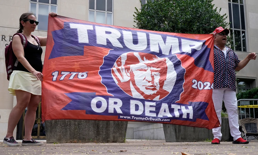 People protest at the E. Barrett Prettyman U.S. Federal Courthouse, Thursday, Aug. 3, 2023, in Washington. Former President Donald Trump is due in federal court in Washington today, to answer charges he sought to overturn his 2020 presidential election loss. (AP Photo/Mariam Zuhaib)