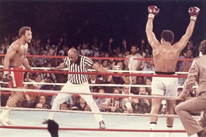 Muhammad Ali, med armene hevet i været, går til sitt hjørne mens dommer Zack Clayton har telt ut George Foreman etter at Ali slo ham ned i åttende runde av deres tittelkamp i Kinshasa, Zaïre, 30. oktober 1974. Foto: AP/NTB