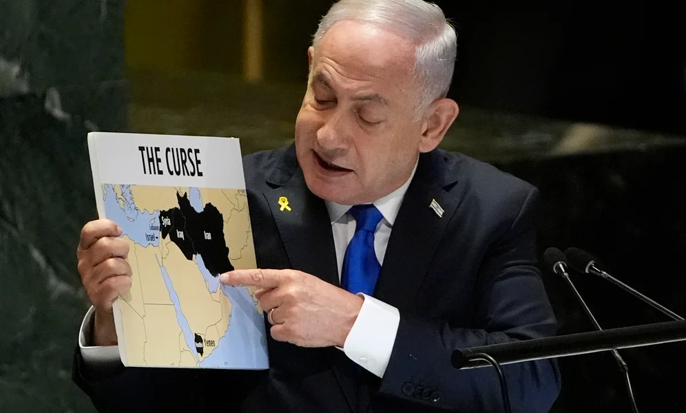 Prime Minister of Israel Benjamin Netanyahu hold a sign as he addresses the 79th session of the United Nations General Assembly, Friday, Sept. 27, 2024. (AP Photo/Pamela Smith)