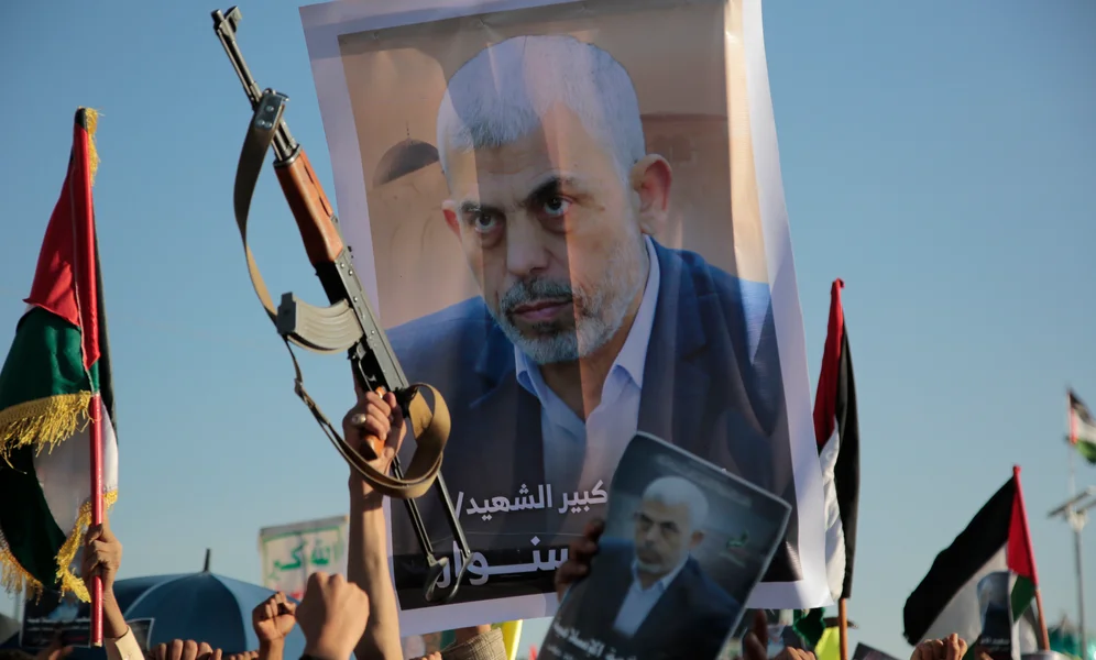 Houthi supporters raise a poster of Hamas leader Yahya Sinwar, who killed by Israeli troops in Gaza, during an anti-Israel rally in Sanaa, Yemen, Friday, Oct. 18, 2024. (AP Photo/Osamah Abdulrahman)