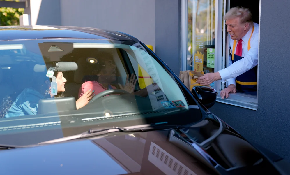 Customers react as Republican presidential nominee former President Donald Trump hands them an order at a drive-thru window during a campaign stop at a McDonald's, Sunday, Oct. 20, 2024, in Feasterville-Trevose, Pa. (AP Photo/Evan Vucci)