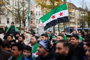 Syrians wave Syrian opposition flags at a rally in Wuppertal, Germany, Sunday, Dec. 8, 2024, following the fall of Syrian president Bashar Assad’s government. (Christoph Reichwein/dpa/dpa via AP)